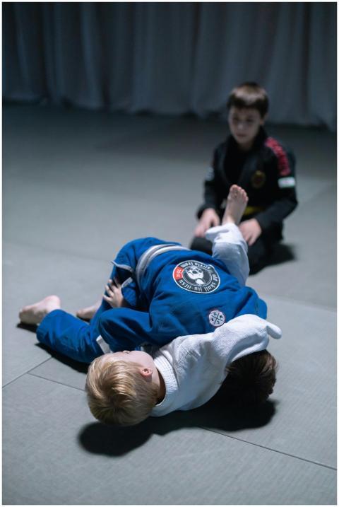 Children practicing jiu-jitsu indoors, demonstrati
