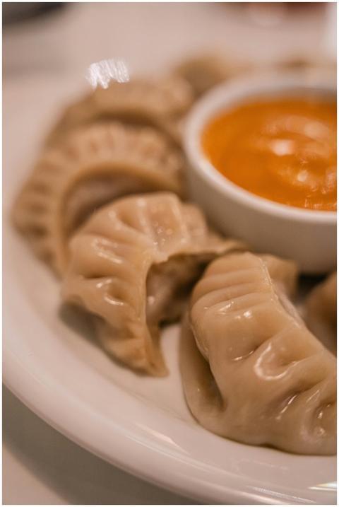 Appetizing dumplings served with spicy orange sauc
