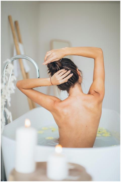 A woman enjoying a relaxing bath surrounded by can
