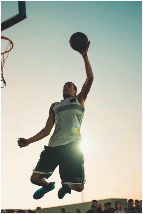 Basketball player performing a powerful dunk durin