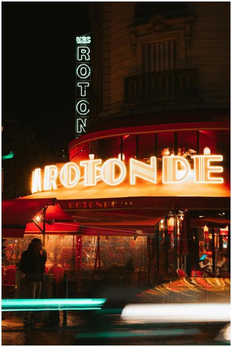 A vibrant night scene at La Rotonde cafe in Paris