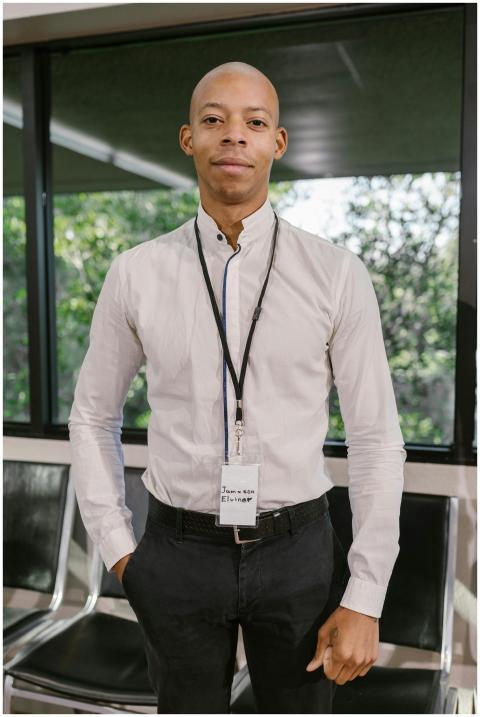 A confident businessman in a white shirt stands in