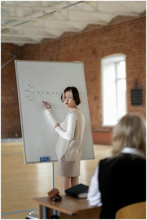 Female student presenting a math problem on a whit