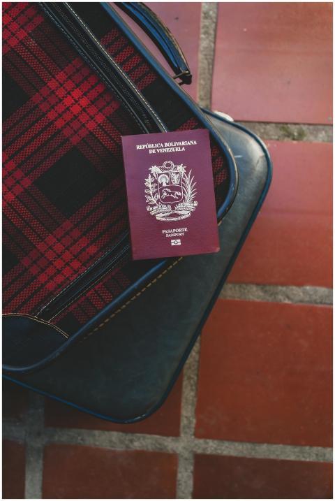 Close-up of Venezuelan passport atop plaid suitcas