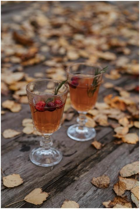Two glass cups of warm berry tea on a wooden table