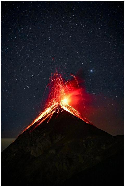 A breathtaking view of a volcano eruption with glo