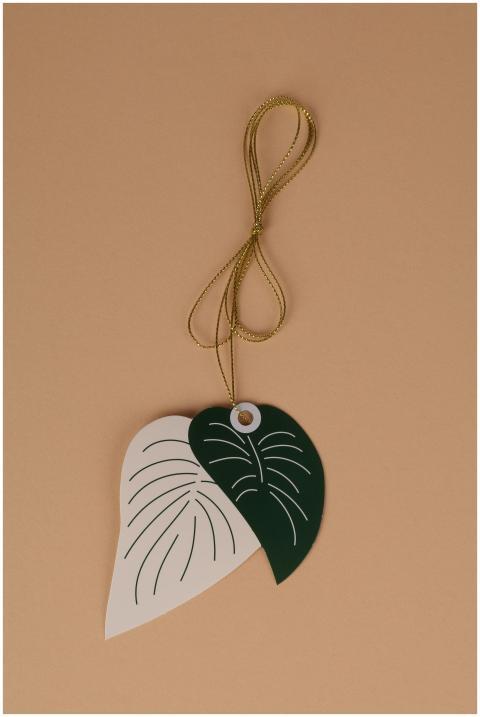 A decorative leaf-shaped tag with a golden string