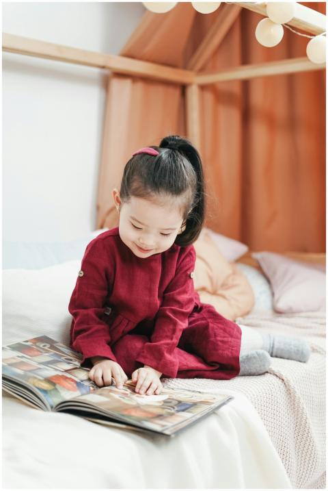 Cute child reading a colorful picture book on the