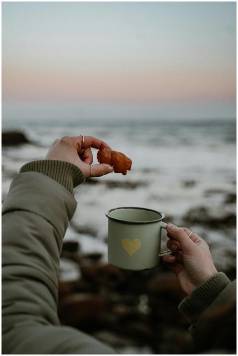 Cozy morning by the sea holding a mug and pastry a