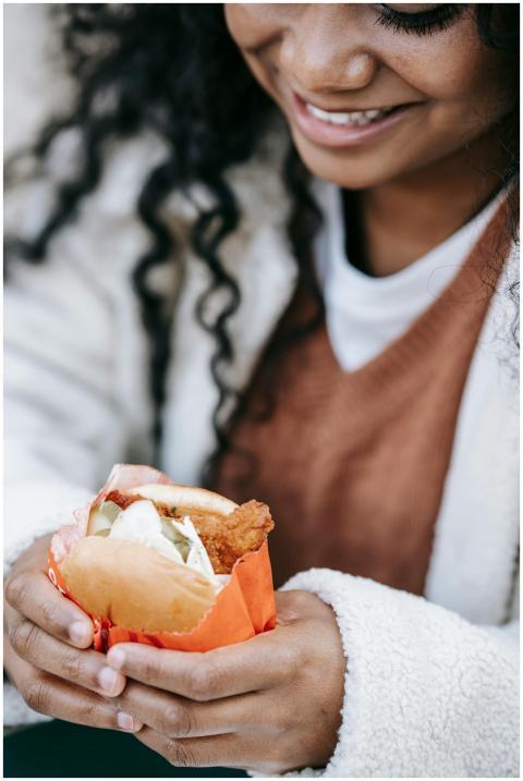 A young woman with curly hair delights in eating a