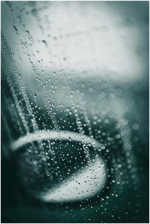 Close-up of raindrops on a car window, creating a