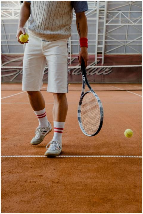 Tennis player holding racket on clay court, hittin