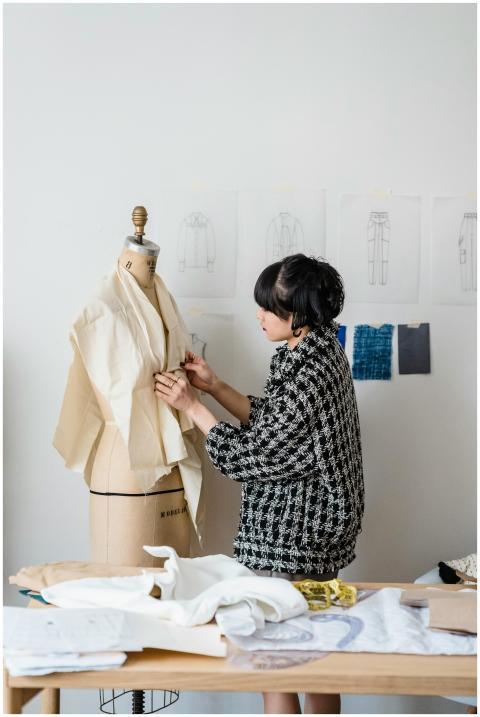 Woman fashion designer working on a dress in a bri