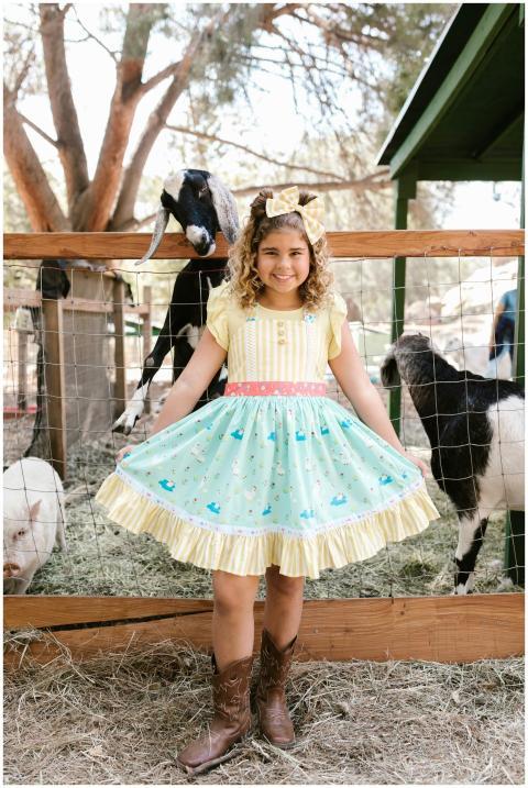 Young girl in colorful dress poses happily with go