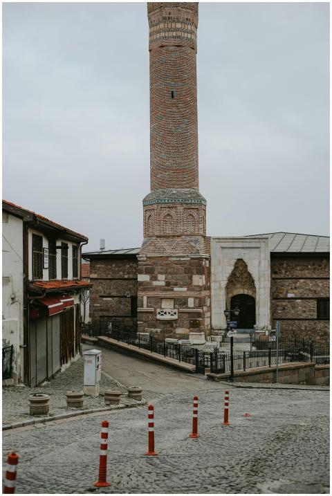 Stone minaret rising in a historic urban area, fea