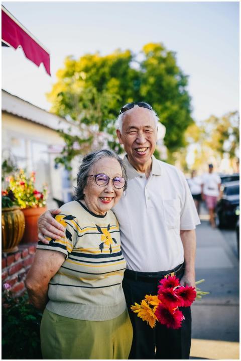 A happy elderly couple embracing outdoors, holding