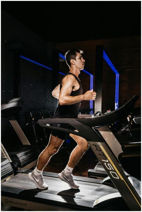 Man exercising on a treadmill indoors, showcasing