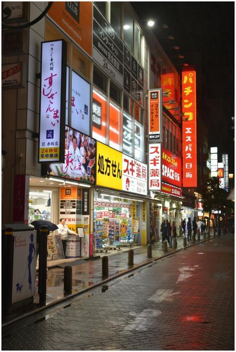 A bustling Tokyo street scene at night, featuring
