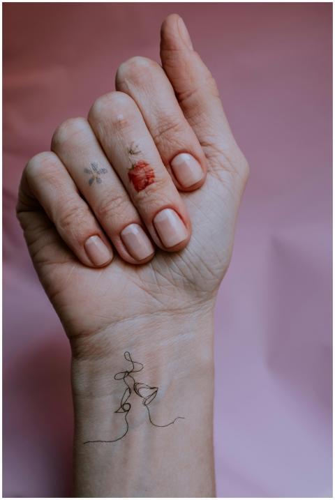 A close-up of a hand with floral temporary tattoos