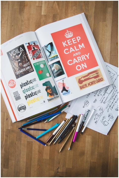 Open book with design elements and pencils on a wo