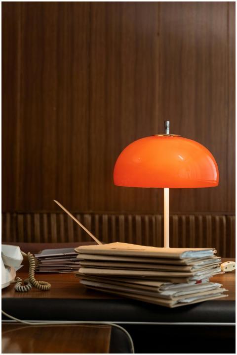 Retro office setting with a red lamp and stacked f