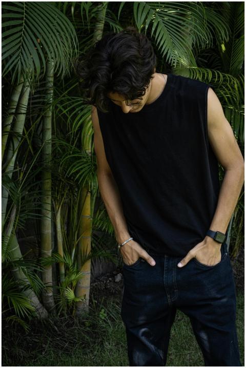 Casual young man in black sleeveless top standing