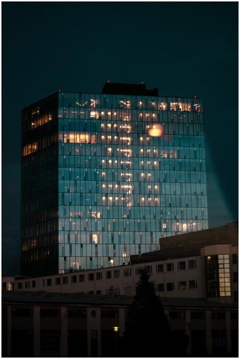 Nighttime cityscape featuring a modern glass offic