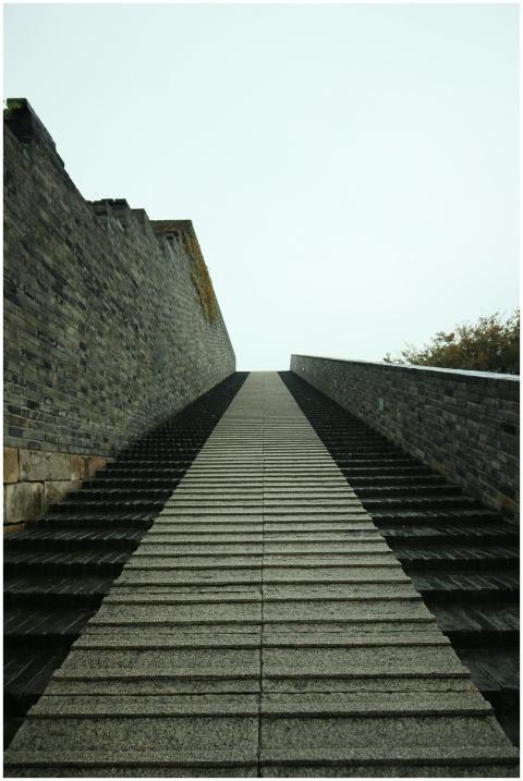 Dramatic upward view of stone steps alongside a hi
