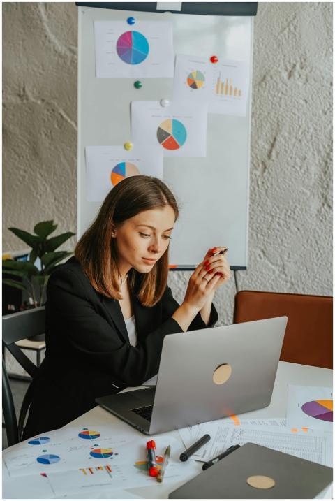 Businesswoman reviewing charts at a laptop in an o