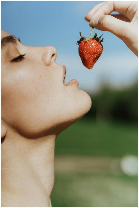 Close-up of a woman about to eat a fresh strawberr