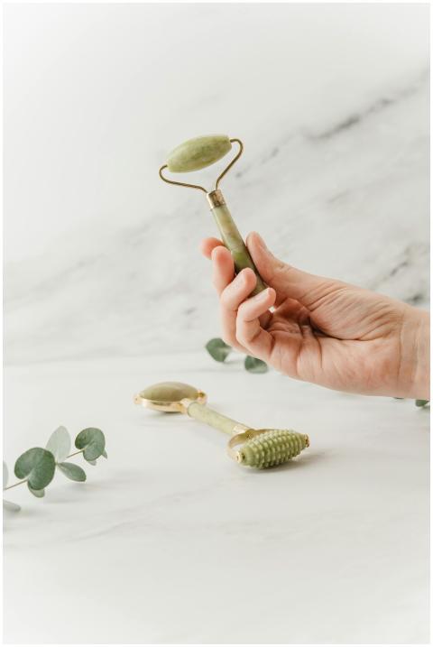 Hand holding a jade roller for skincare and self-c