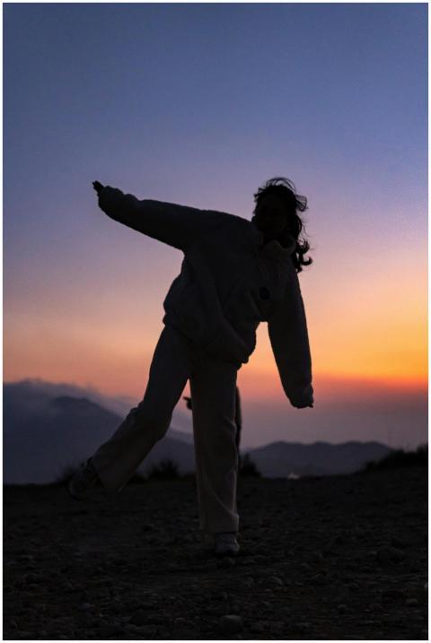 Silhouette of a person dancing playfully during a