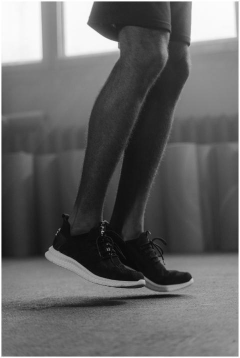 Grayscale image of legs in motion, wearing sneaker