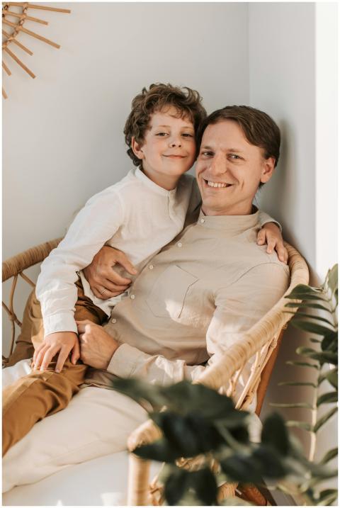 A joyful father and son embracing and smiling whil