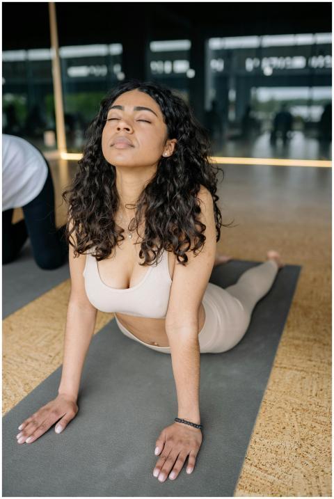 A young woman practicing yoga in a bright studio,
