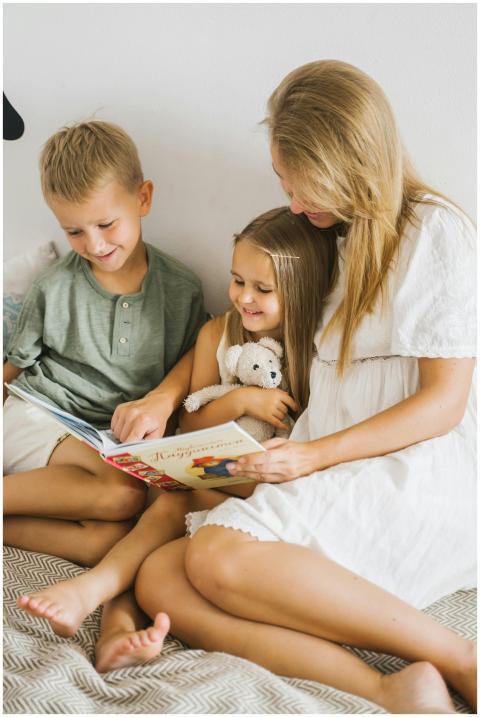 A mother happily reads a storybook with her son an