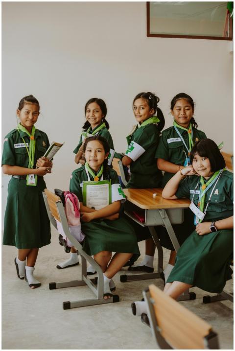 Group of Asian schoolgirls in green uniforms posin