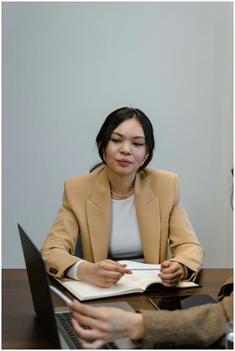 Asian woman in a beige blazer during a business me