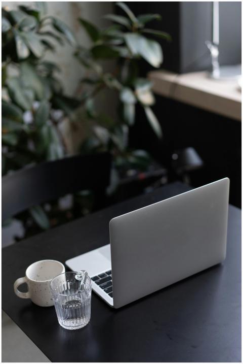 A stylish minimalist workspace with a laptop, cups