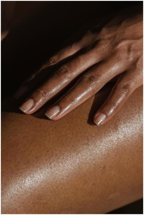 Crop anonymous African American female touching ba
