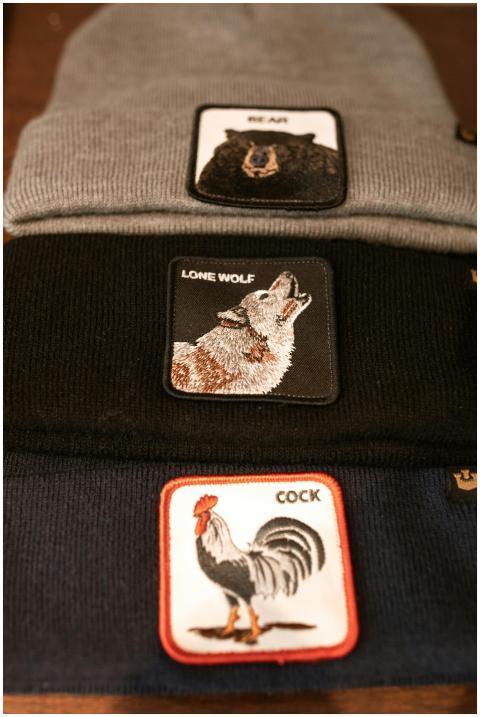 Close-up of three beanies featuring animal patches