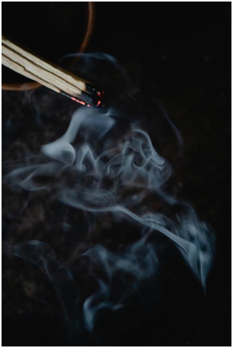 A close-up view of smoke rising from a lit incense