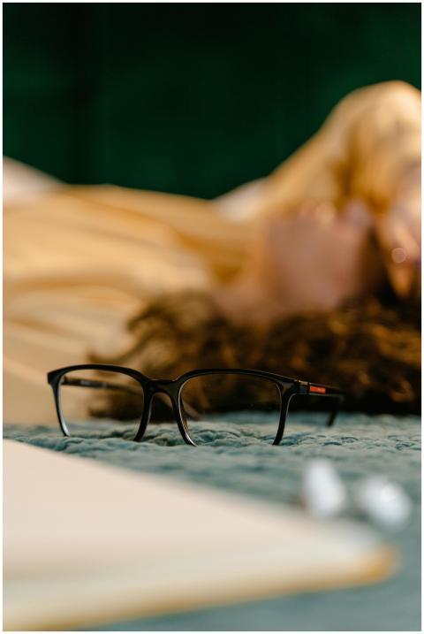 Close-up of eyeglasses on bed with blurred backgro