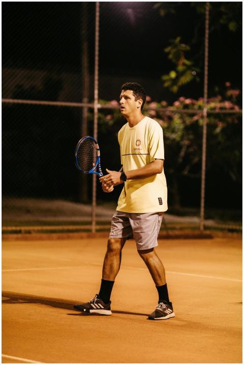 Young male tennis player focused during a nighttim