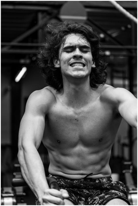 Determined young man intensely working out on a ro