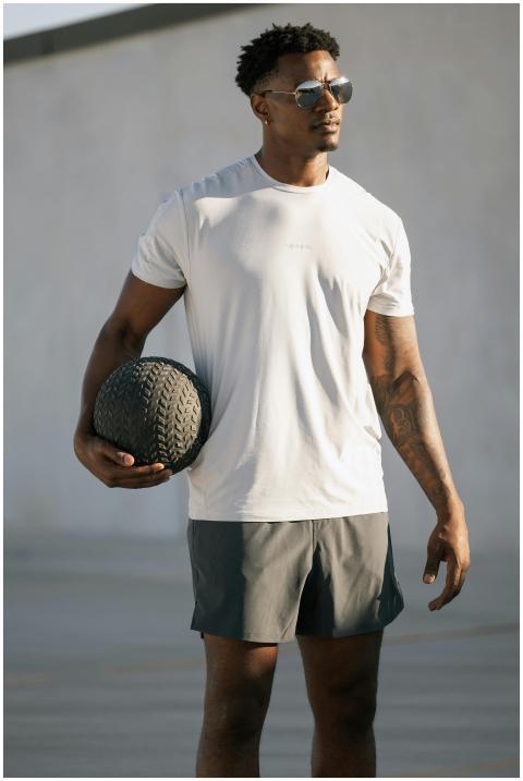 Young male wearing athleisure holding exercise bal