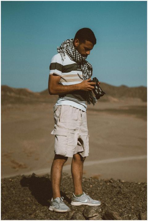 A young man with a camera explores the desert land