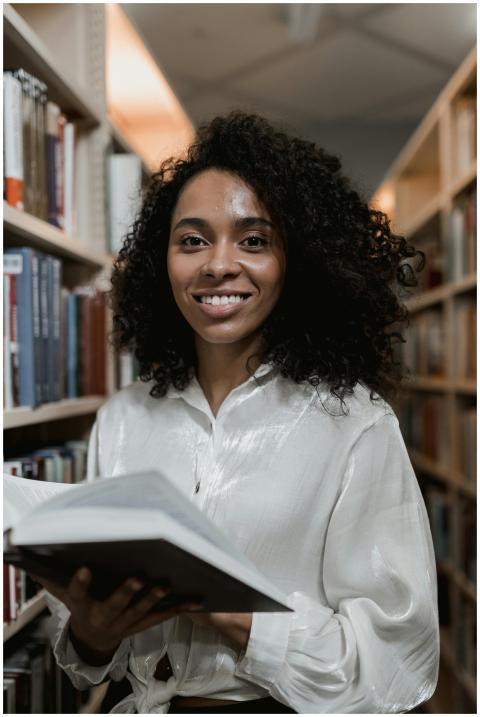 Smiling African American woman holding a book in t