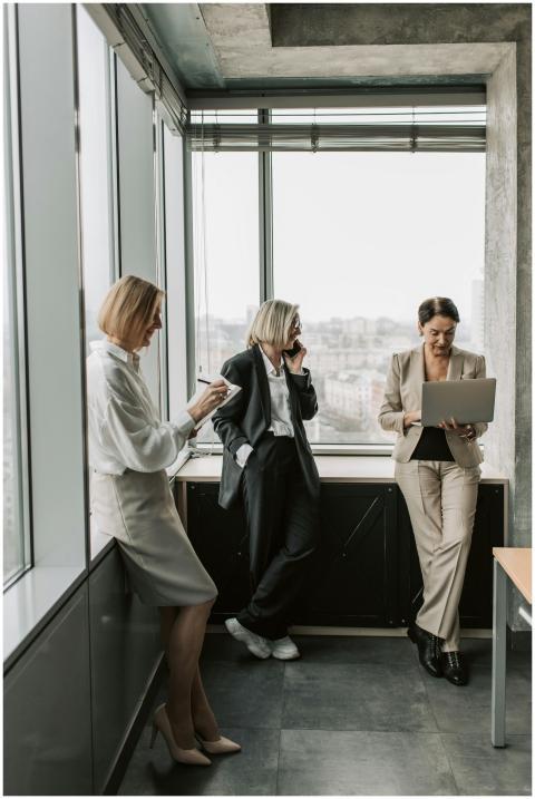 Three businesswomen in a modern office setting, wo