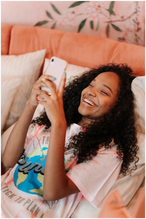 Teen girl joyfully using her smartphone in a cozy